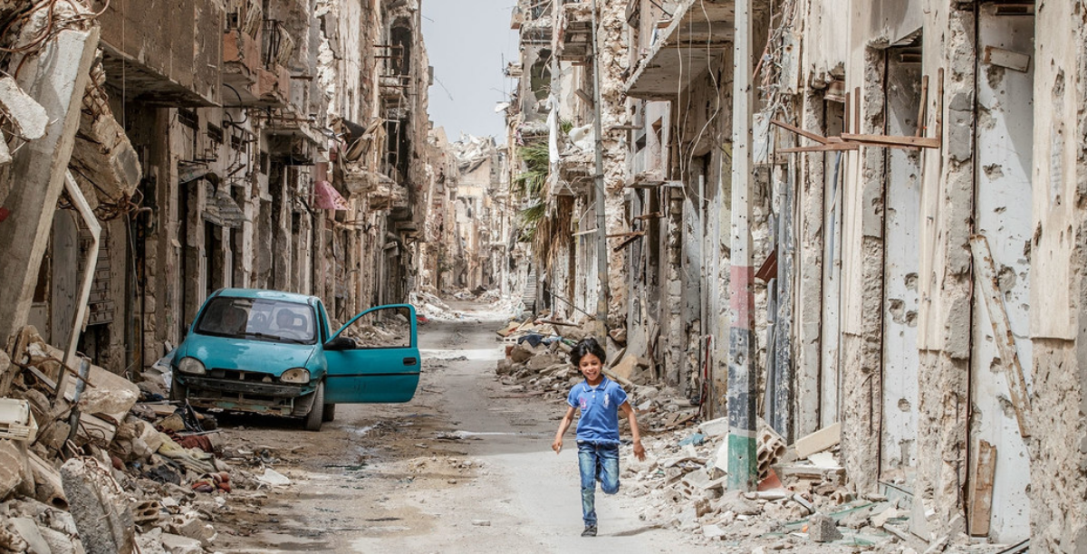 Unicef_Giovanni Diffidenti Crianca corre entre destruicao em Benghazi, na Libia Unicef_Giovanni Diffidenti Crianca corre entre destruicao em Benghazi, na Libia