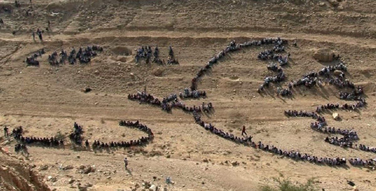 peace Vista aérea de um grupo de pessoas a replicar o desenho da pomba da paz de Picasso, numa criação do artista Jonh Quigley, no Monte das Tentações. Foto © UNRWA.