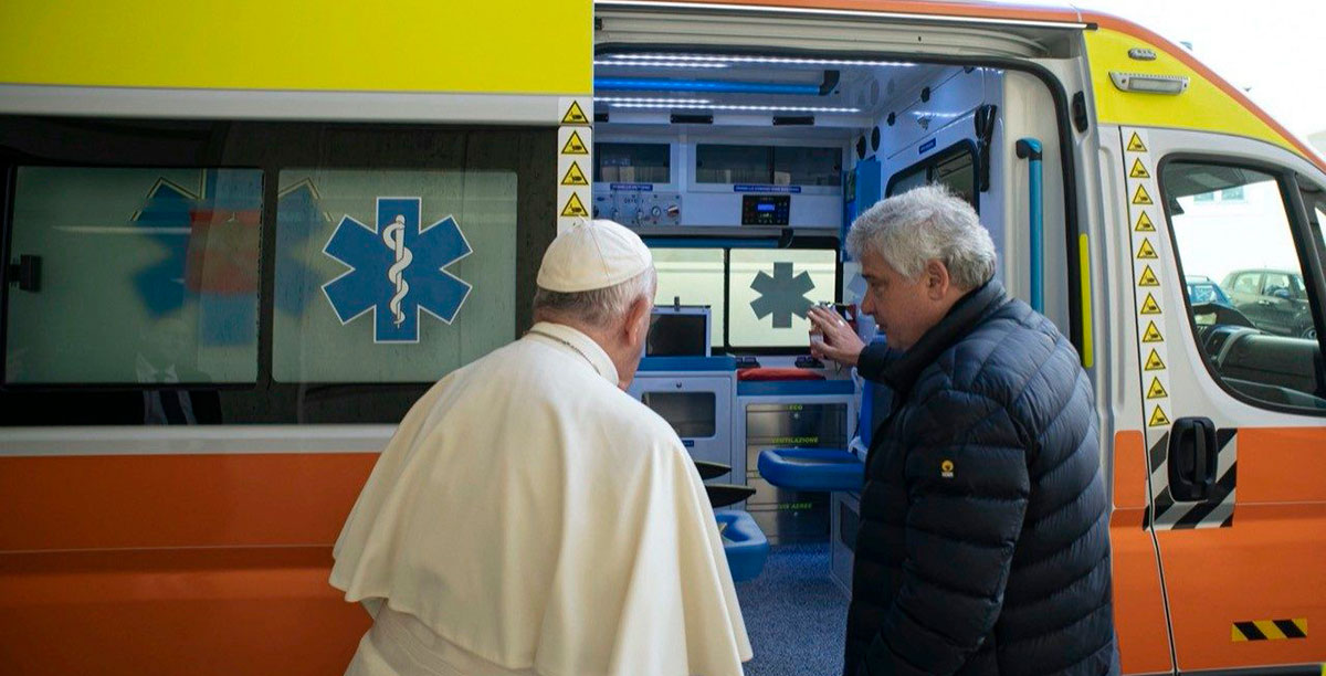 Papa Francisco abençoa a ambulância que vai doar à Ucrânia na companhia do cardeal Konrad Krajewski, esmoler pontifício. Foto © Vatican Media