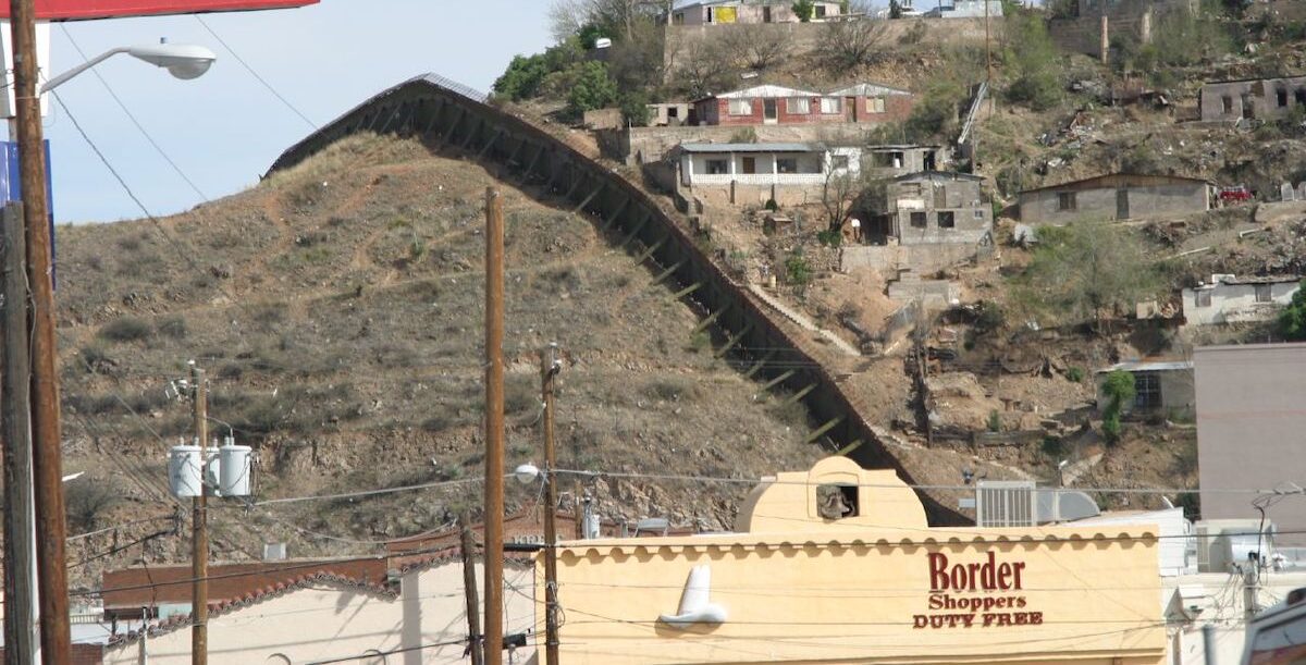 Arizona-Mexico_border_-_Flickr_-_Allen_Ormond O muro que os EUA erigiram na fronteira com o México, aqui no Arizona. Foto © Allen Ormond from Novi, MI, USA, CC BY 2.0 , via Wikimedia Commons.