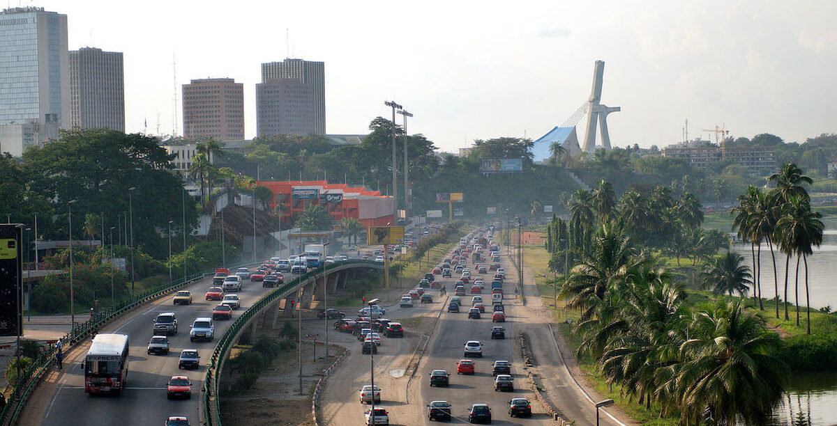 Boulevard_De_Gaulle_-_Abidjan A catedral de Saint-Paul, em Abidjan, vista ao fundo, em segundo plano, a partir do Boulevard De Gaulle, no bairro do Plateau. Foto © fr.zil, CC BY-SA 2.0 , via Wikimedia Commons.