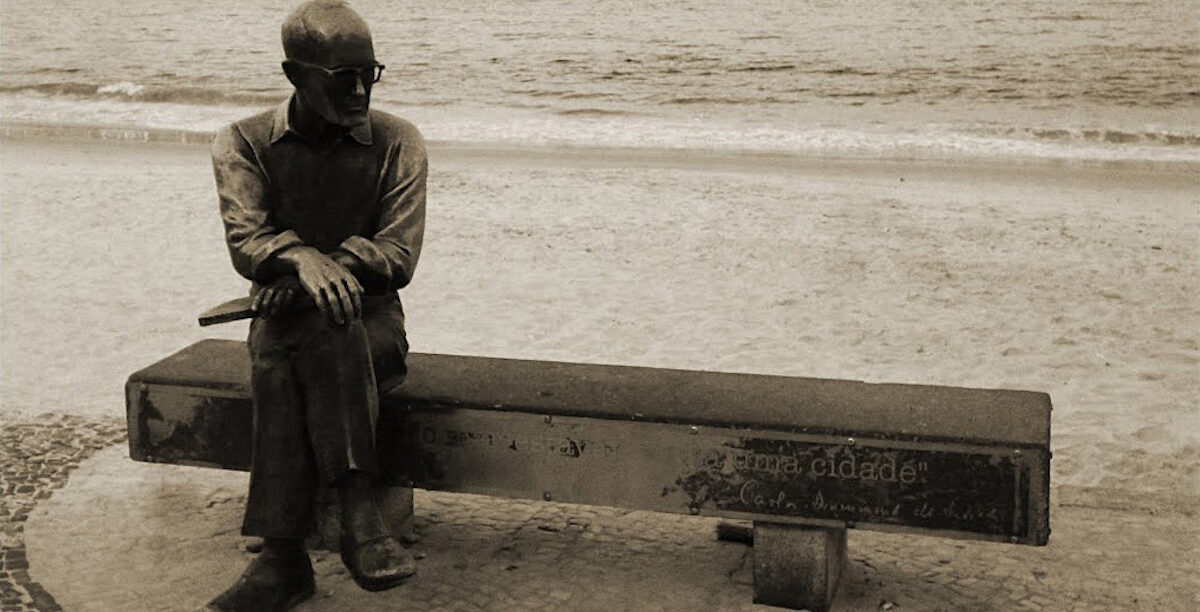 Carlos_Drummond Estátua de Carlos Drummon de Andrade, em Copacabana, no Rio de Janeiro (Brasil). Foto © Okitron, CC BY-SA 3.0 , via Wikimedia Commons
