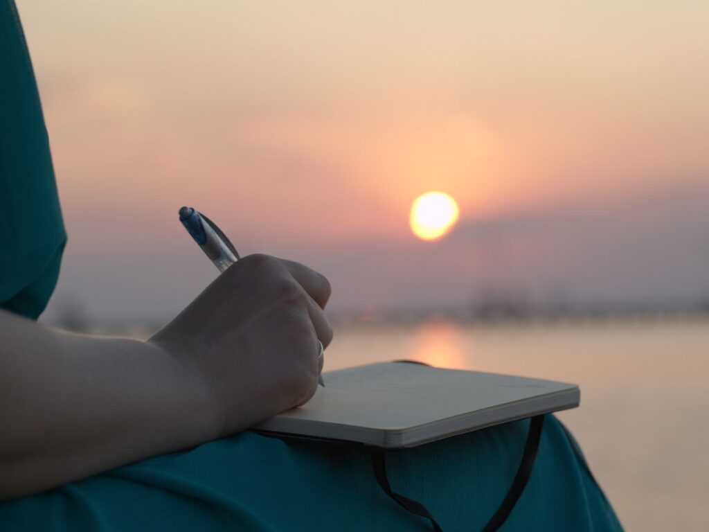 mulher escreve num diario ao por do sol, foto danr13