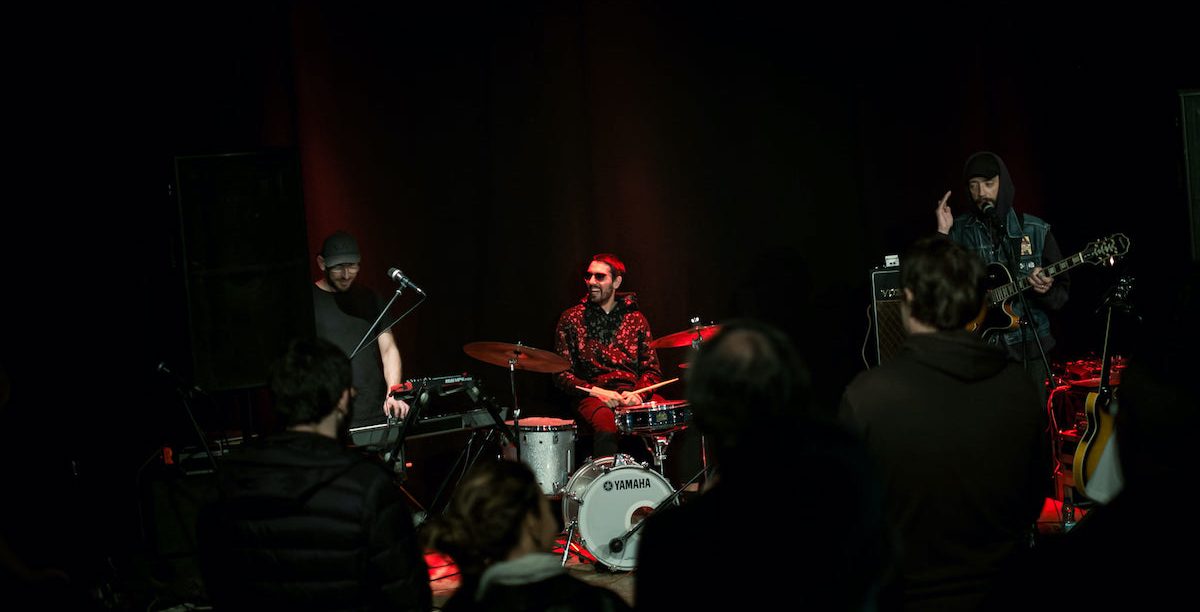 Músicos da FlorCaveira em palco (com Tiago Cavaco à direita). A editora define-se pelo mote "Religião & Panque Roque". Foto da página de Facebook da editora.