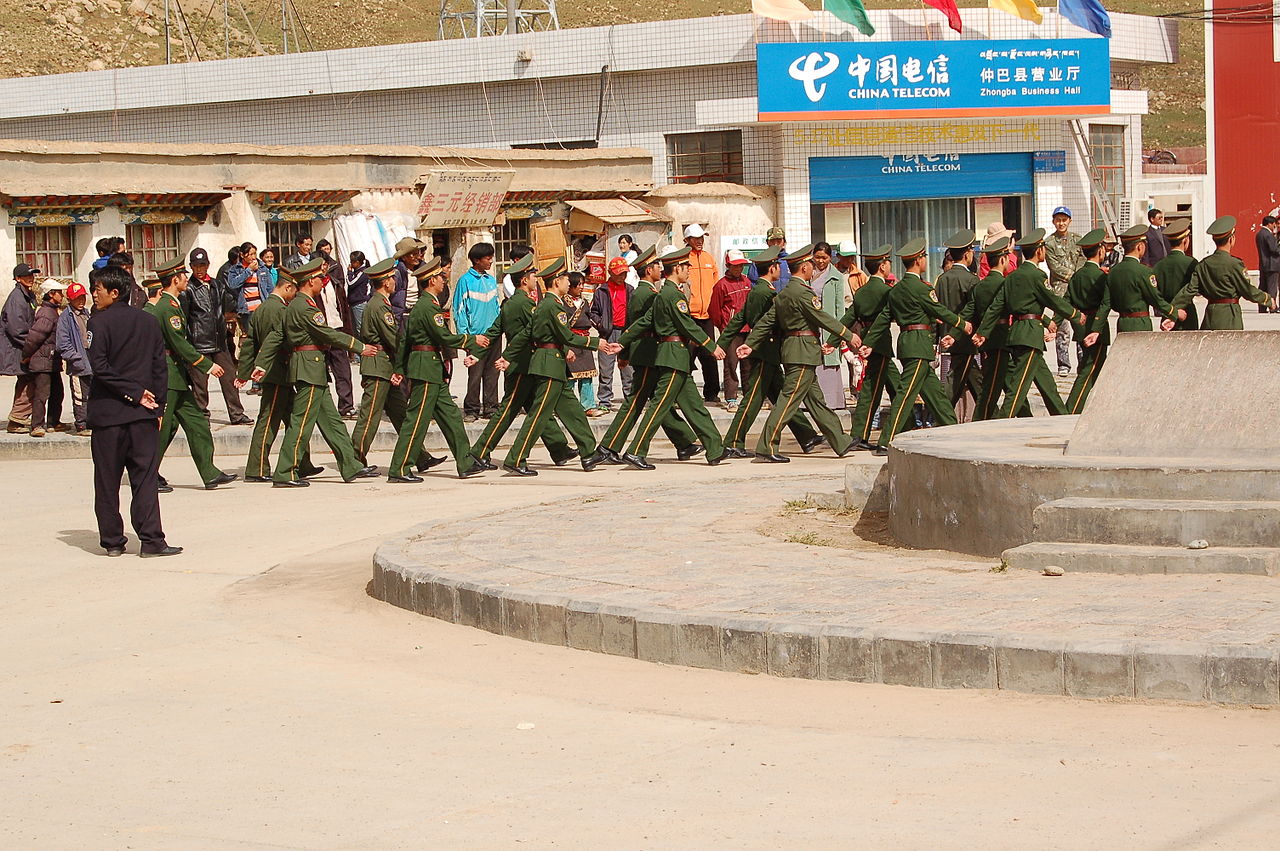 Exército chinês a desfilar pelas ruas de Drongpa (Zhongba) distrito de Shigatse, Tibete, numa foto datada de 2007. Foto © Dieter Schuh, CC BY 3.0 <https://creativecommons.org/licenses/by/3.0>, via Wikimedia Commons.