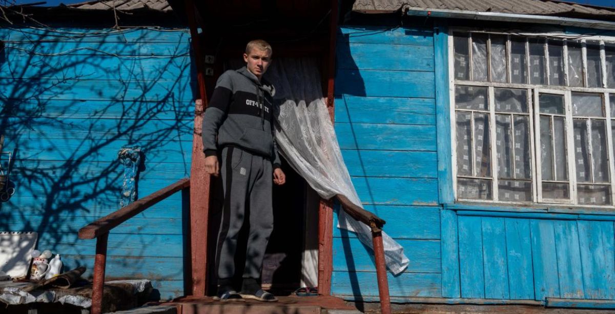 Habriel à porta da casa que ele e a mãe alugaram em Izium. Foto UNICEF