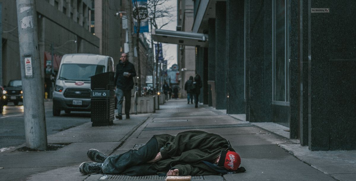 Sem abrigo deitado na rua. Foto Harrison Haines de Pexels