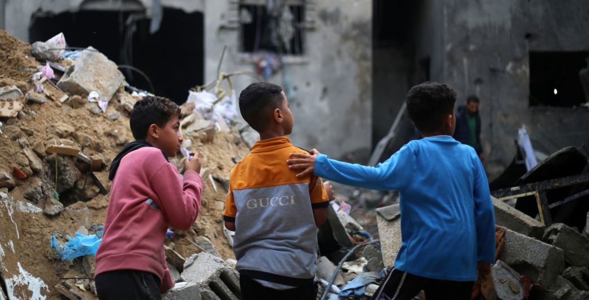 © UNICEFEyad El Baba Crianças olham para suas casas destruídas na cidade de Rafah, no sul da Faixa de Gaza