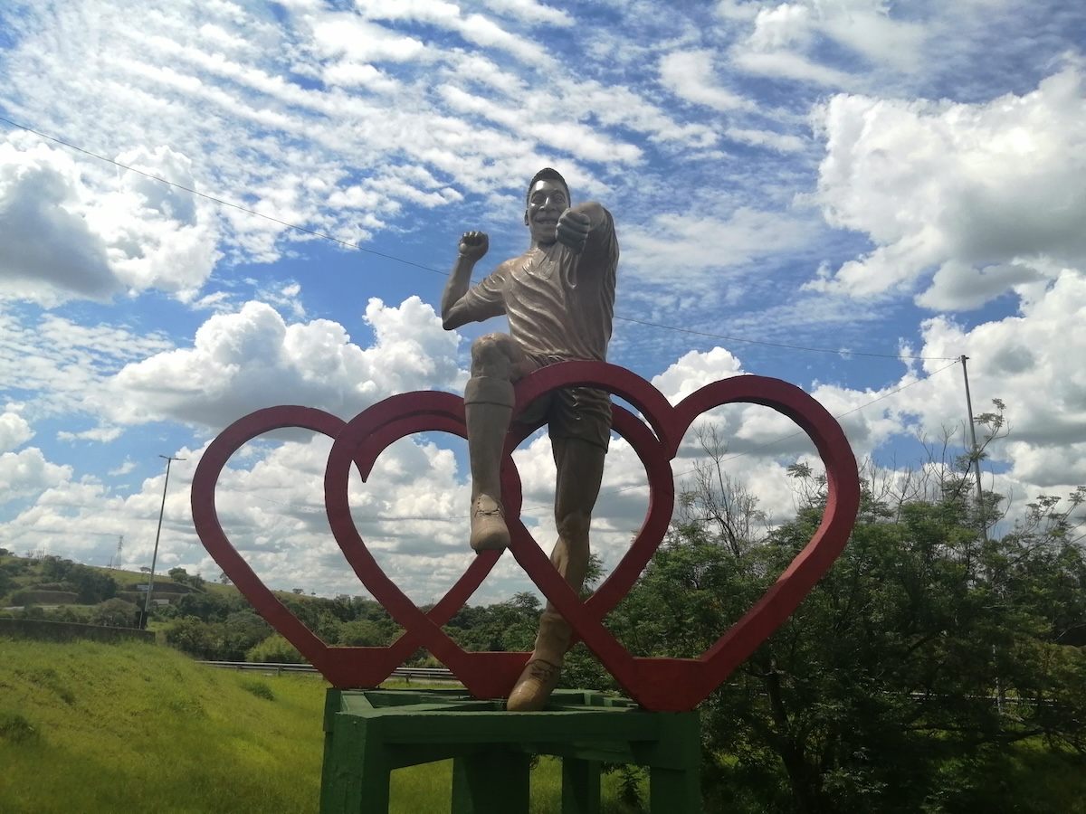 A 280 quilómetros de Belo Horizonte, fui surpreendido com uma grande estátua à margem da Rodovia Fernão Dias. A placa da povoação não deixava dúvidas: Três Corações e a estátua tem o Rei Pelé, melhor jogador do mundo de todos os tempos – assim me garantiram por ali. Janeiro de 2024. Foto © Tony Neves.