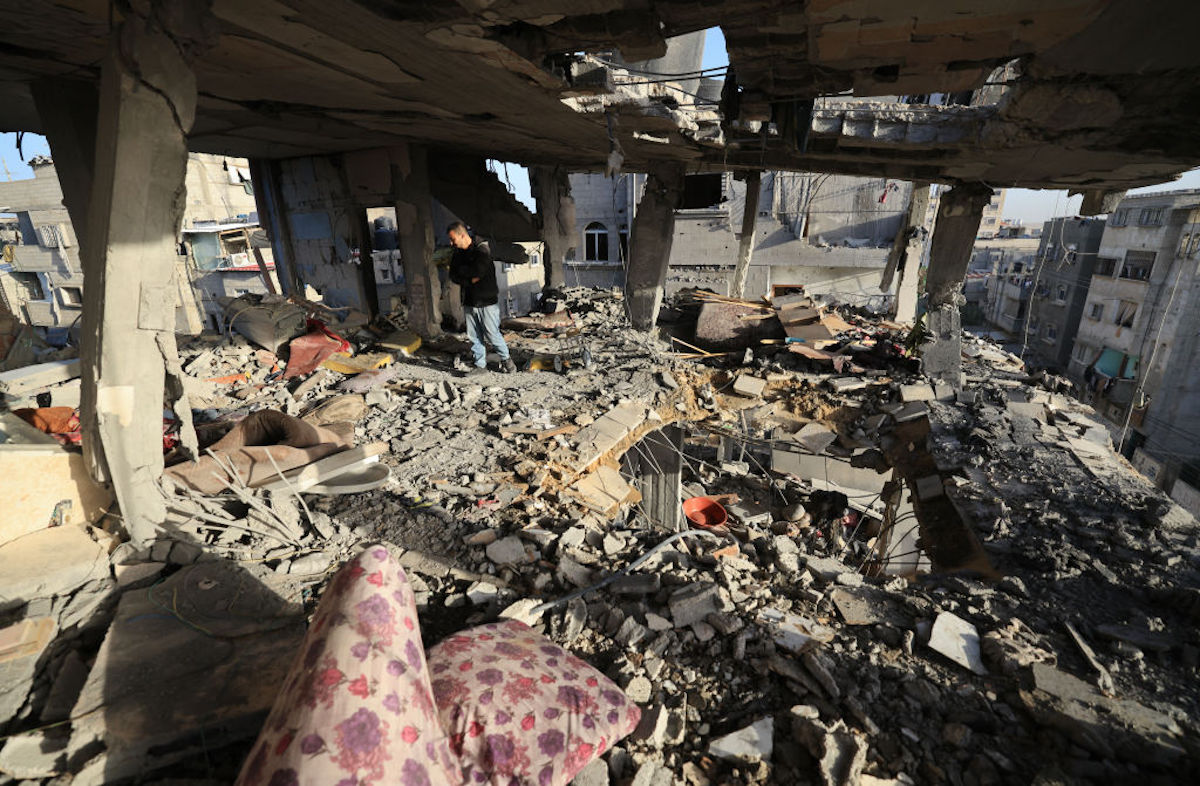 Homem verifica os danos na casa da família palestiniana Nofal, atingida a 10 de janeiro de 2024. Foto © AFP via Getty Images. UTILIZAR A FOTO APENAS EM NOTÍCIAS DA AMNISTIA INTERNACIONAL SOBRE GAZA