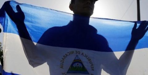 Nicarágua: mais dois padres expulsos e enviados para Roma Um homem segura uma bandeira nacional durante uma missa pela paz na Nicarágua na catedral de Manágua. Foto Vatican Media