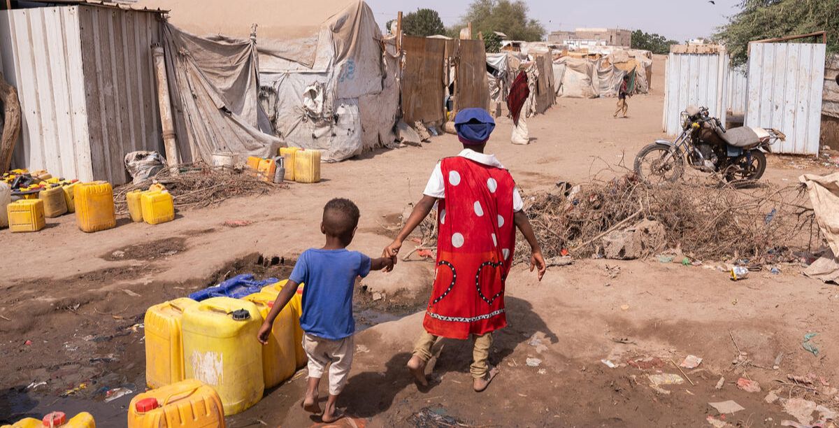 Duas crianças caminham em campo de deslocados no Iémen. Foto Save the Children