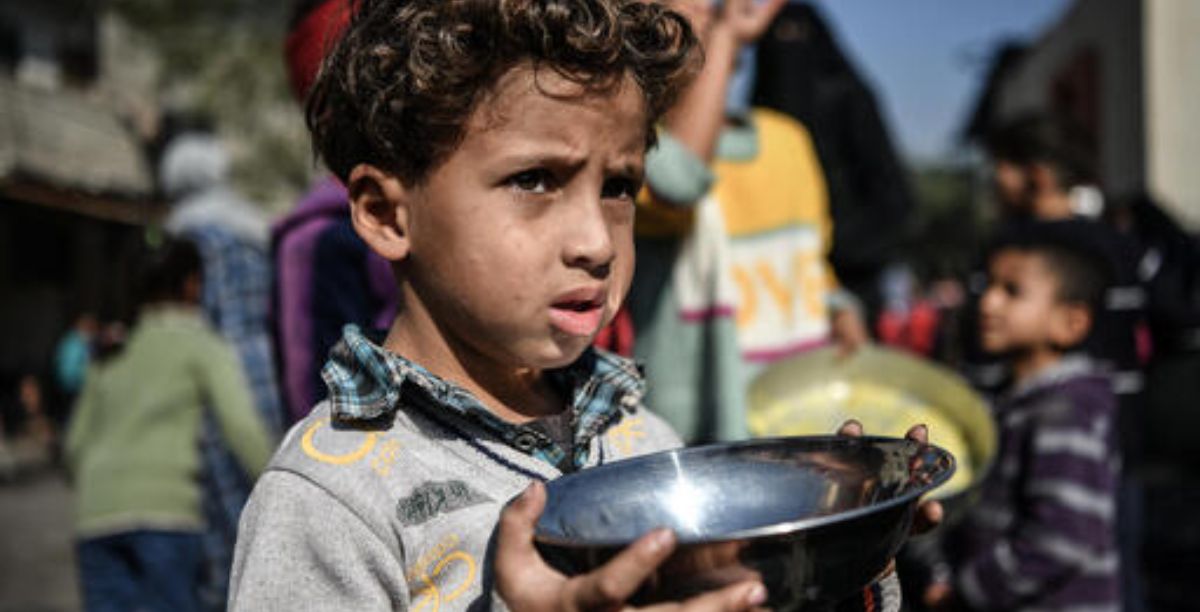 Uma criança de 5 anos espera a sua vez para obter comida, em Rafah, Faixa de Gaza. Foto Abed ZagoutUnicef