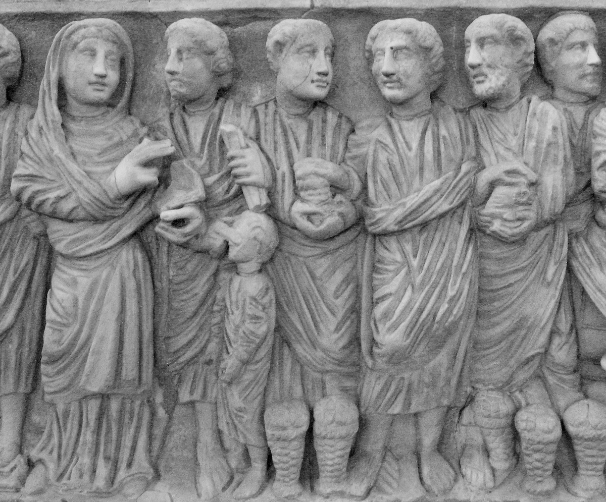 Sarcófago frisado do início do século IV, no Museu Pio Cristão do Vaticano, retratando a mulher falecida em pé, em tamanho real, com um códice e o gesto de oradora imersa em cenas bíblicas. Foto © Christine Schenk CSJ.