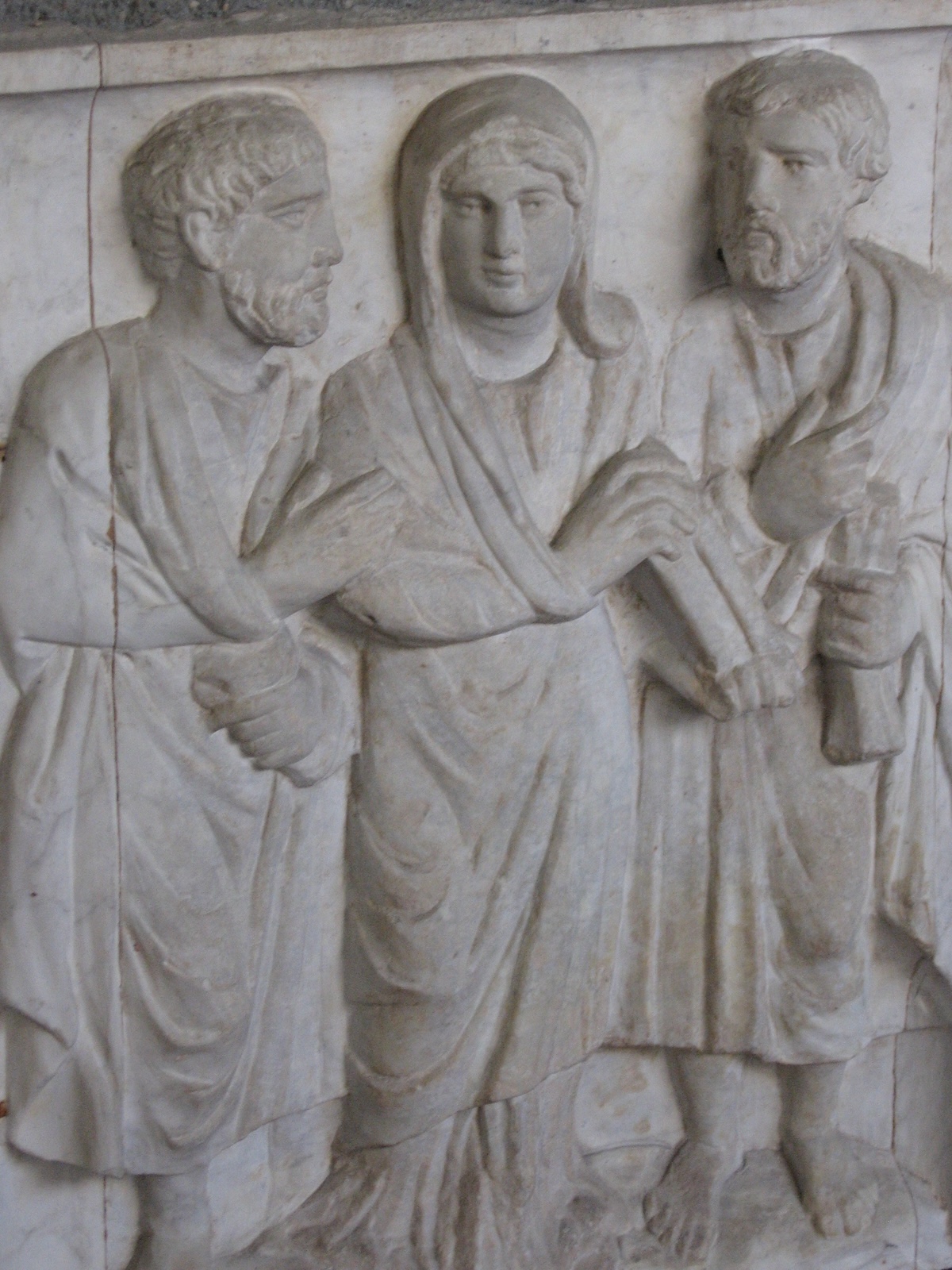 Sarcófago no Museu Pio Cristão, do Vaticano (c. 350 d.C, inv. 31512), representando a mulher falecida a segurar um pergaminho, ladeada por “apóstolos” que a atendem respeitosamente. Foto © Christine Schenk CSJ.