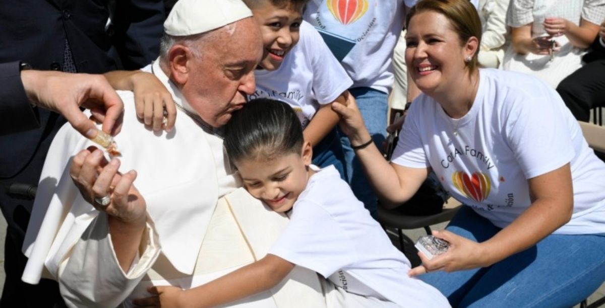 Uma criança abraça o Pana na audiência geral de 26 de junho 2024. Foto Vatican Media