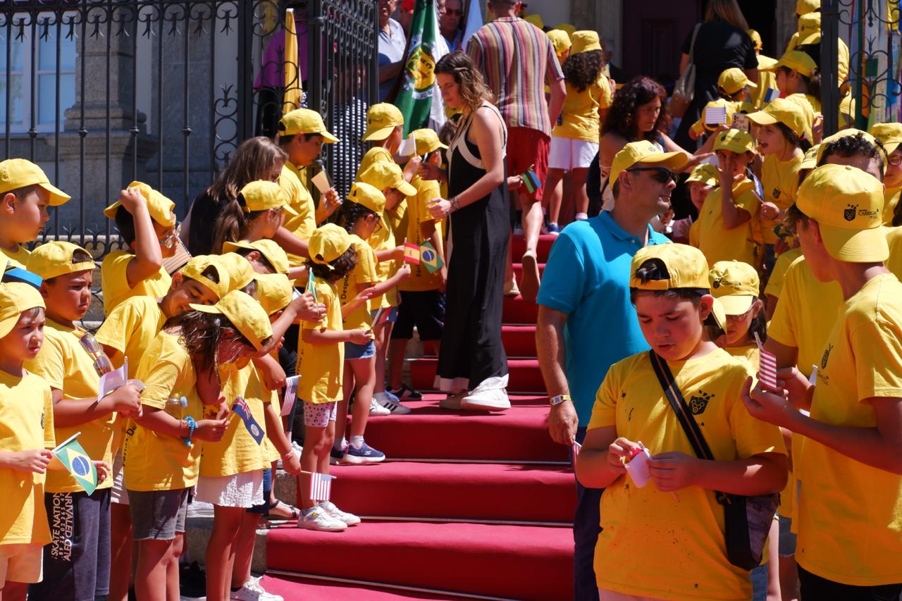 Crianças com as bandeiras dos lugares onde Aristides trabalhou: “Sacrificou a vida para salvar muitas pessoas”. Foto ©️ António Marujo/7MARGENS