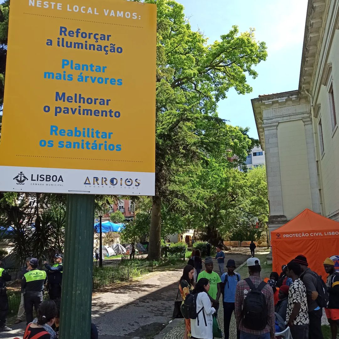 A Câmara Municipal de Lisboa e a Junta de Freguesia de Arroios afixaram cartazes pelo jardim. Em letras coloridas, lia-se: “Neste local vamos: reforçar a iluminação; plantar mais árvores; melhorar o pavimento.” Foto © Cozinha Migrante dos Anjos.