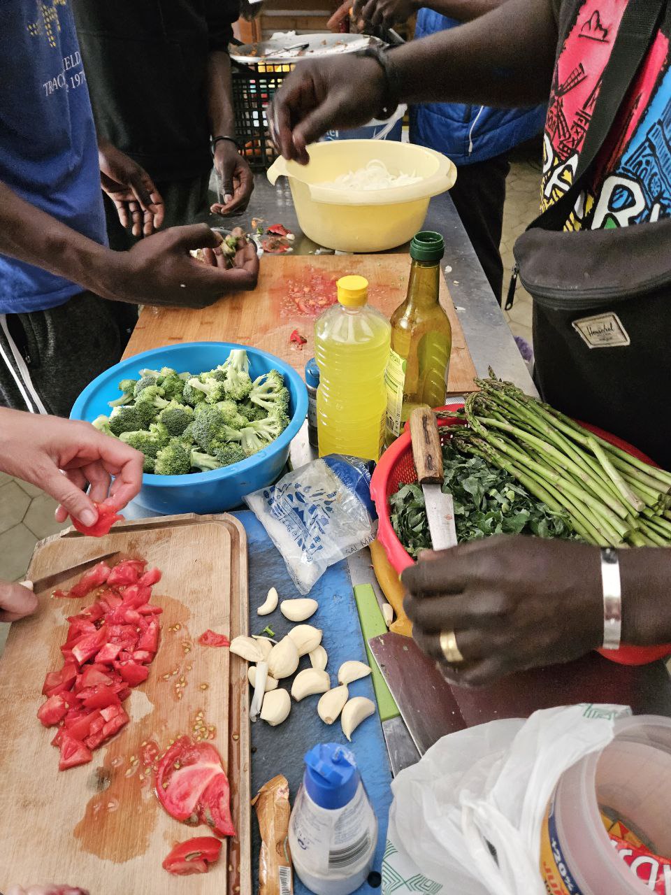 Muitas mãos na cozinha. «Há muitas dificuldades em África, muita pobreza. Por isso arriscámos a vida e viemos cá simplesmente para trabalhar.» Foto © Cozinha Migrante dos Anjos.