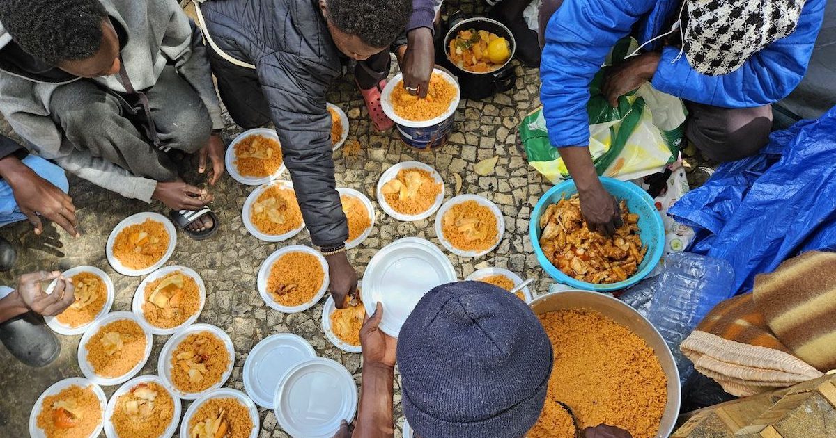 distribuiçãocomida Pelas duas da tarde, o almoço está pronto. Num ápice, carregada por dois jovens, a pesada panela sobe os degraus do centro social para o clarão e o calor da rua. Foto © Cozinha Migrante dos Anjos.