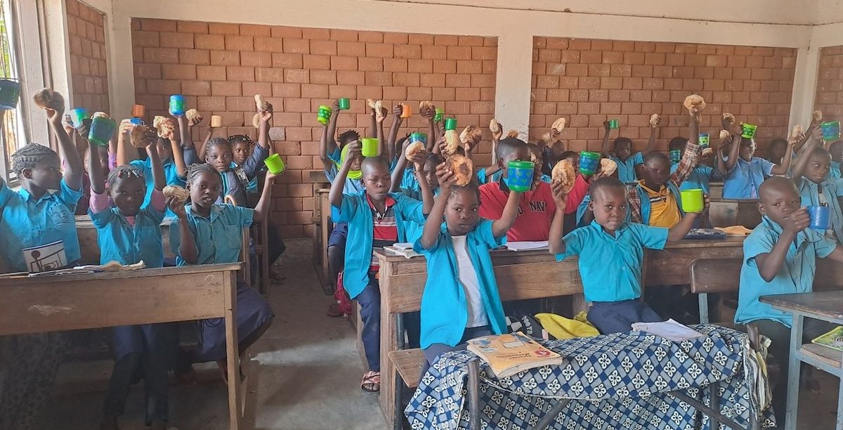 Os 1 291 alunos da Escola Primária Completa de Nawitipele, na província de Nampula, em Moçambique, começaram a receber na última semana, e pela primeira vez, um lanche escolar. Foto da página de Facebook da Helpo.