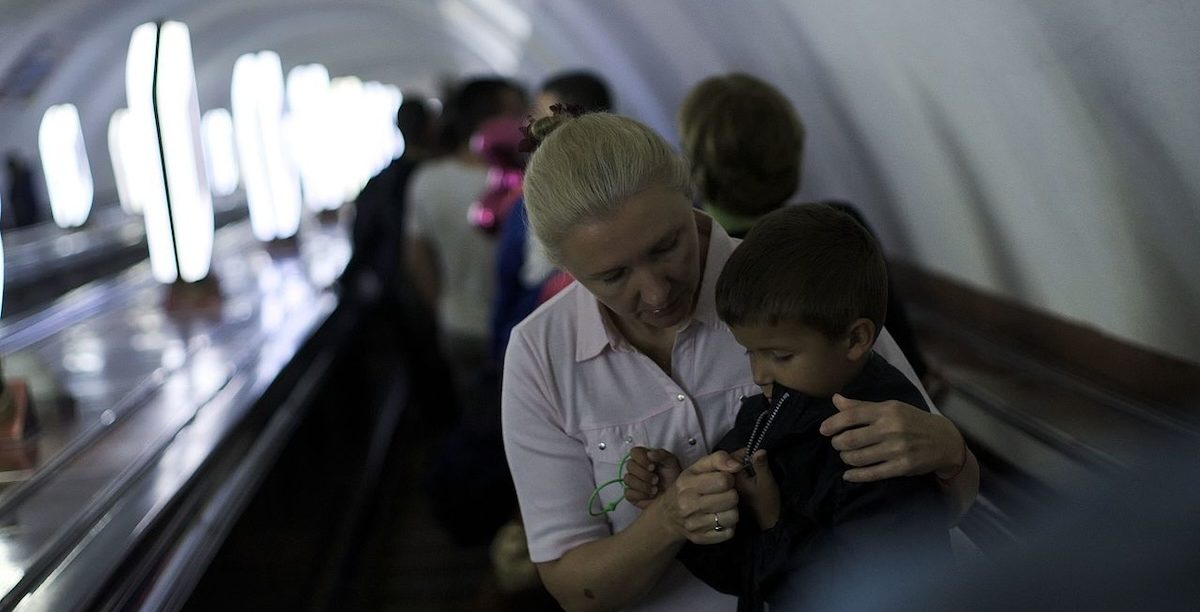 Em 2023, 708 milhões de mulheres (com 15 anos ou mais) não trabalhavam por terem de prestar cuidados a outras pessoas. Na imagem, mulher com criança na Ucrânia. Foto © spoilt.exile from Kiev, Ukraine, CC BY-SA 2.0, via Wikimedia Commons.
