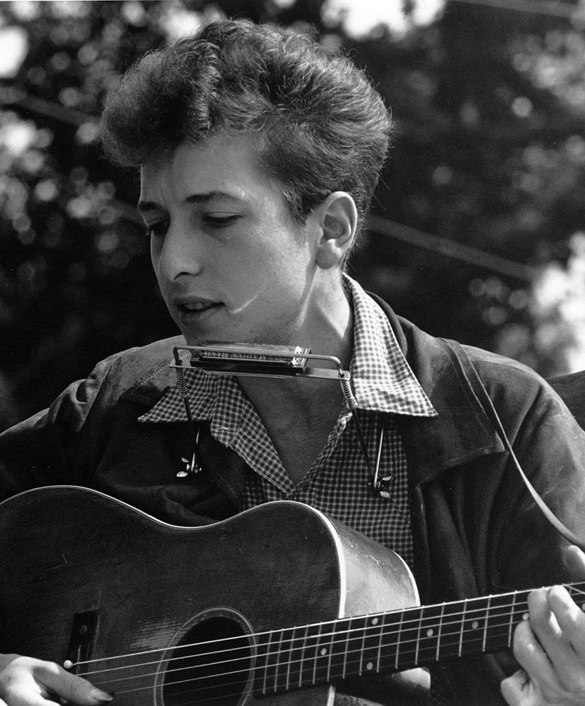 Livre, sozinho e solitário, de viola na mão e mochila às costas, Dylan partiu para Nova Iorque em busca de uma “centelha de luz”. Foto © Rowland Scherman, Public domain, via Wikimedia Commons