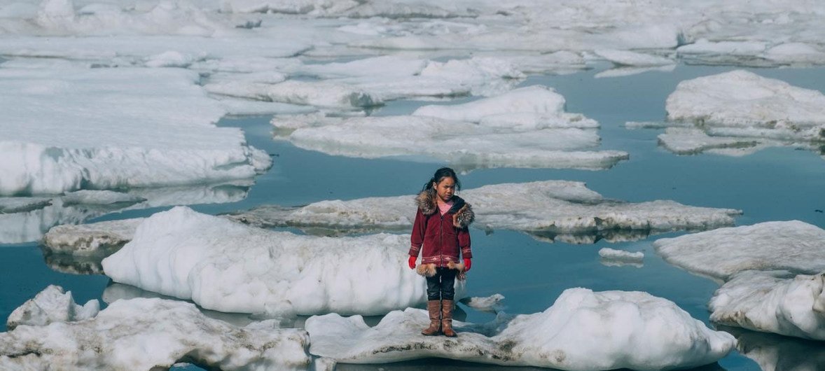 Unicef/Vlad Sokhin Uma menina da comunidade Iñupiat está em um bloco de gelo na costa do Oceano Ártico em Barrow, Alasca, nos Estados Unidos