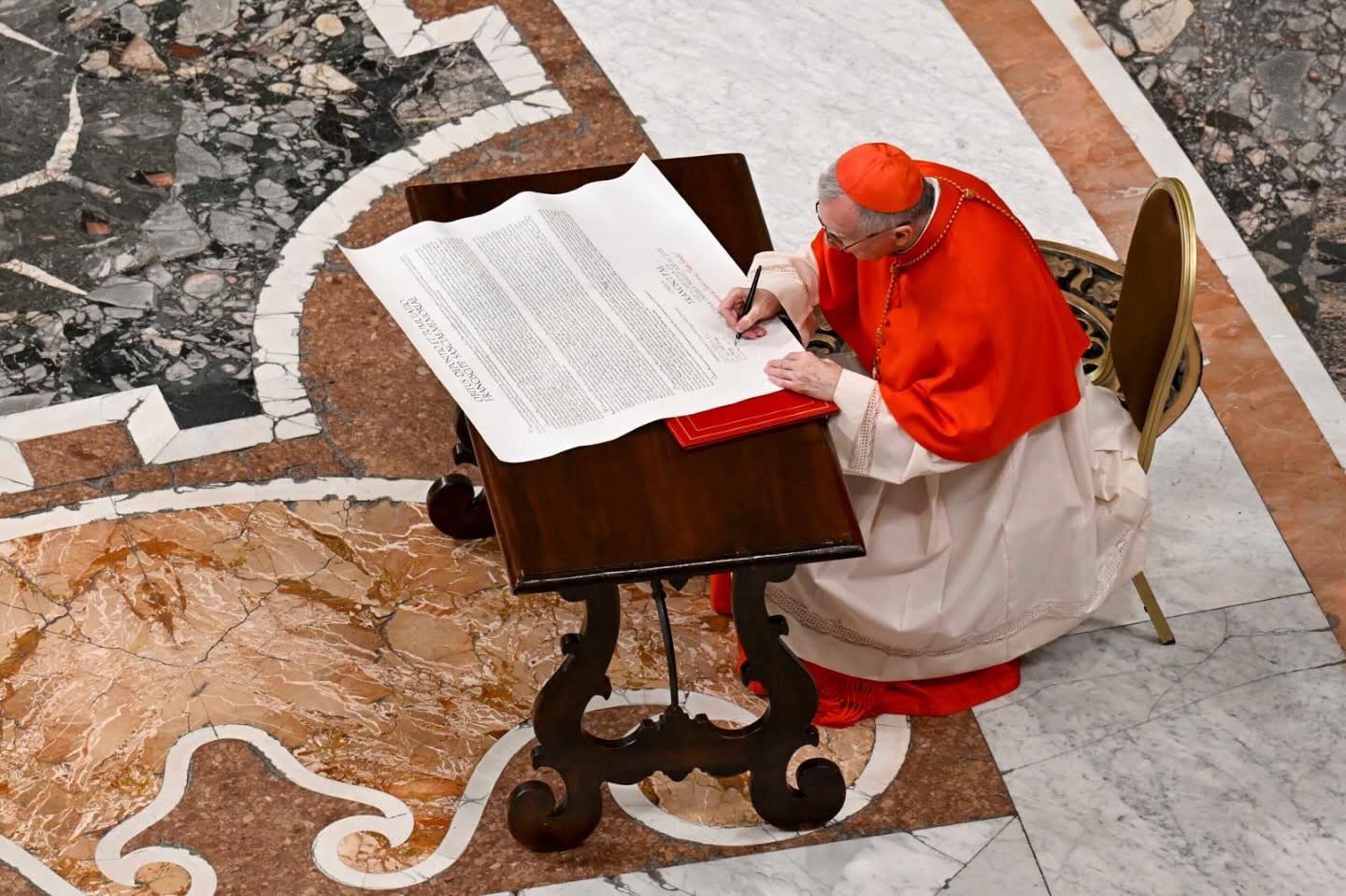 O cardeal Pietro Parolin assina o rogitum do Papa Francisco. Foto Vatican Media