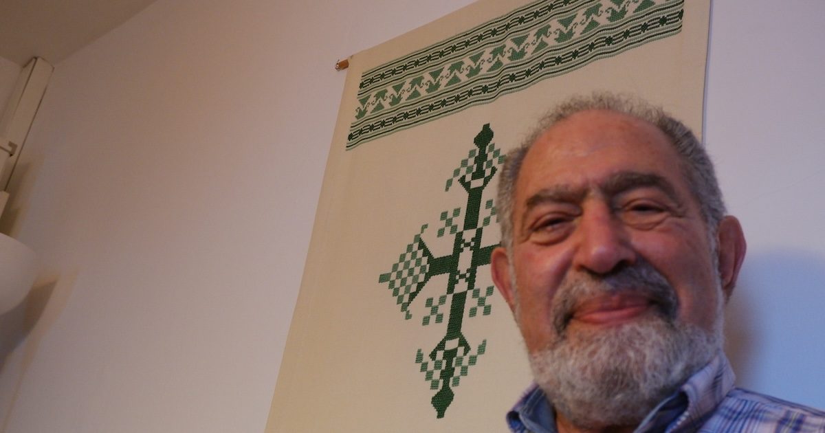 Adel Sidarus junto a uma cruz copta bordada. Foto © António Marujo