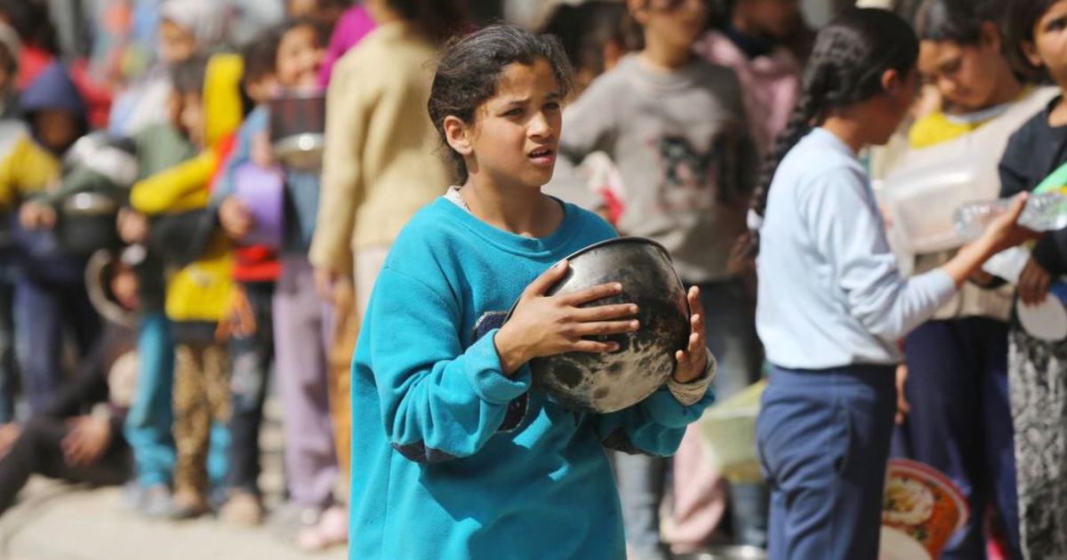 Famílias esperam distribuição de comida em Gaza. © Unrwa