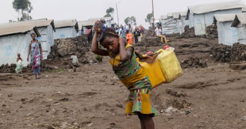 © AcnurBlaise Sanyila Uma jovem coleta água em um acampamento para deslocados na República Democrática do Congo