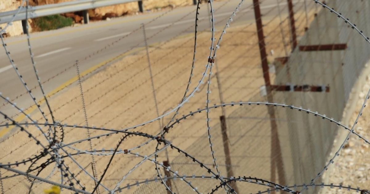 Closed military road passing under a gate at one of the enclaves in Northwest Jerusalem. Foto © CMI-WCC-EAPPI-
