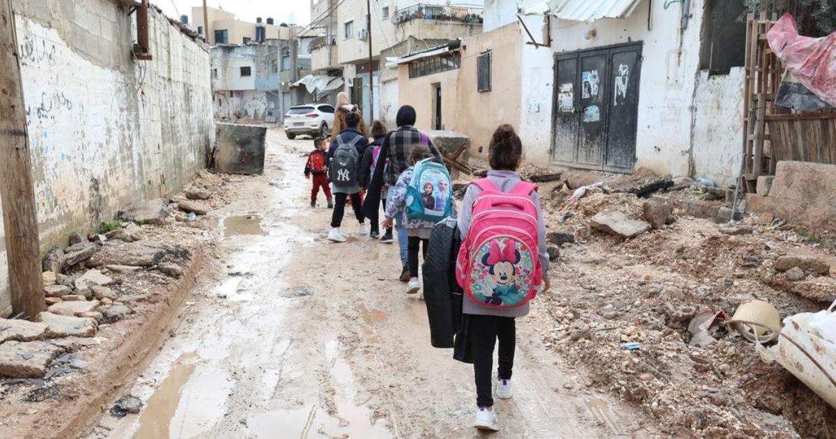 © UNICEFAlaa Badarneh Crianças caminham por ruas parcialmente destruídas em Jenin, na Cisjordânia.