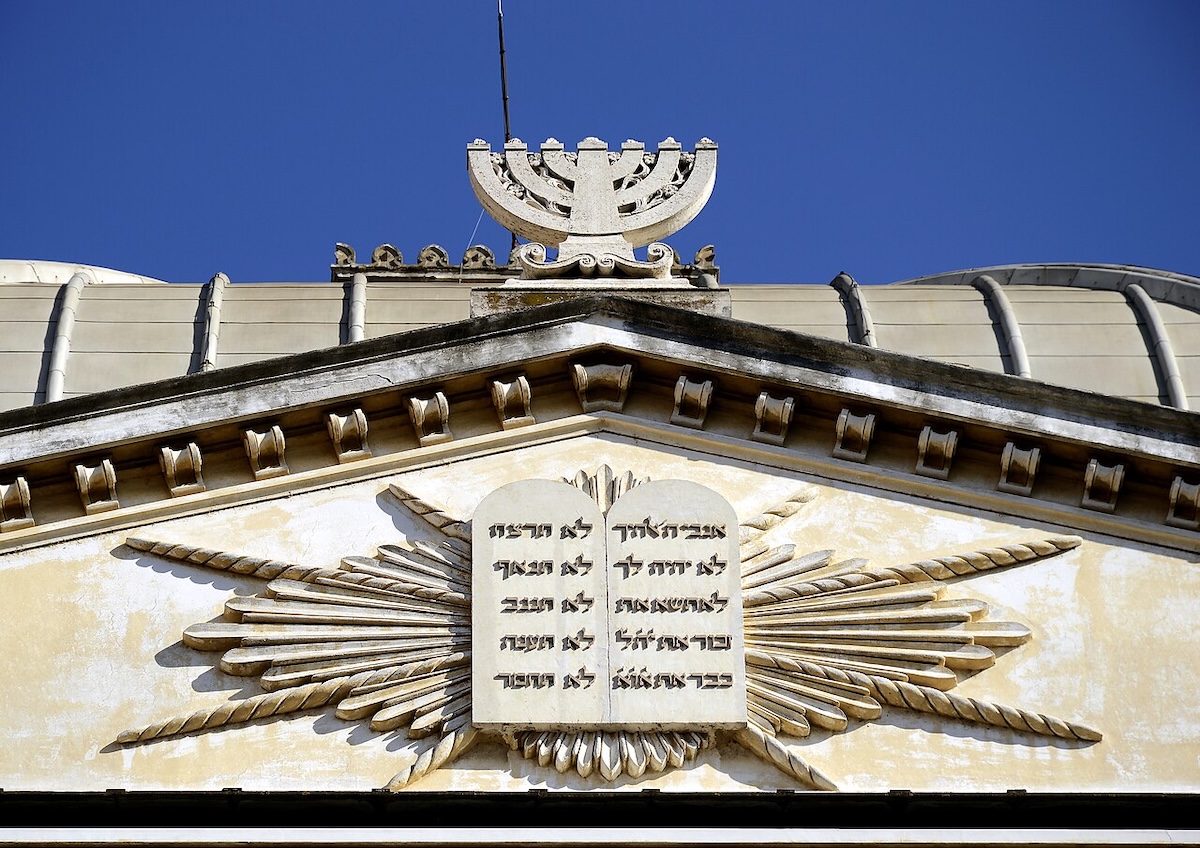 A menorá e as tábuas da lei esculpidas na Sinagoga de Roma. Foto © Livioandronico2013, via Wikimedia Commons.https://commons.wikimedia.org/wiki/File:Menorah_and_Tables_of_the_Law_on_Great_Synagogue_(Rome).jpg