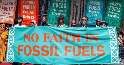 Centena e meia de organizações religiosas francesas pedem fim dos combustíveis fósseis manifestantes de diferentes religiões seguram cartaz com mensagem No faith in fossil fuels. Foto Fossil Fuel Treaty Initiative