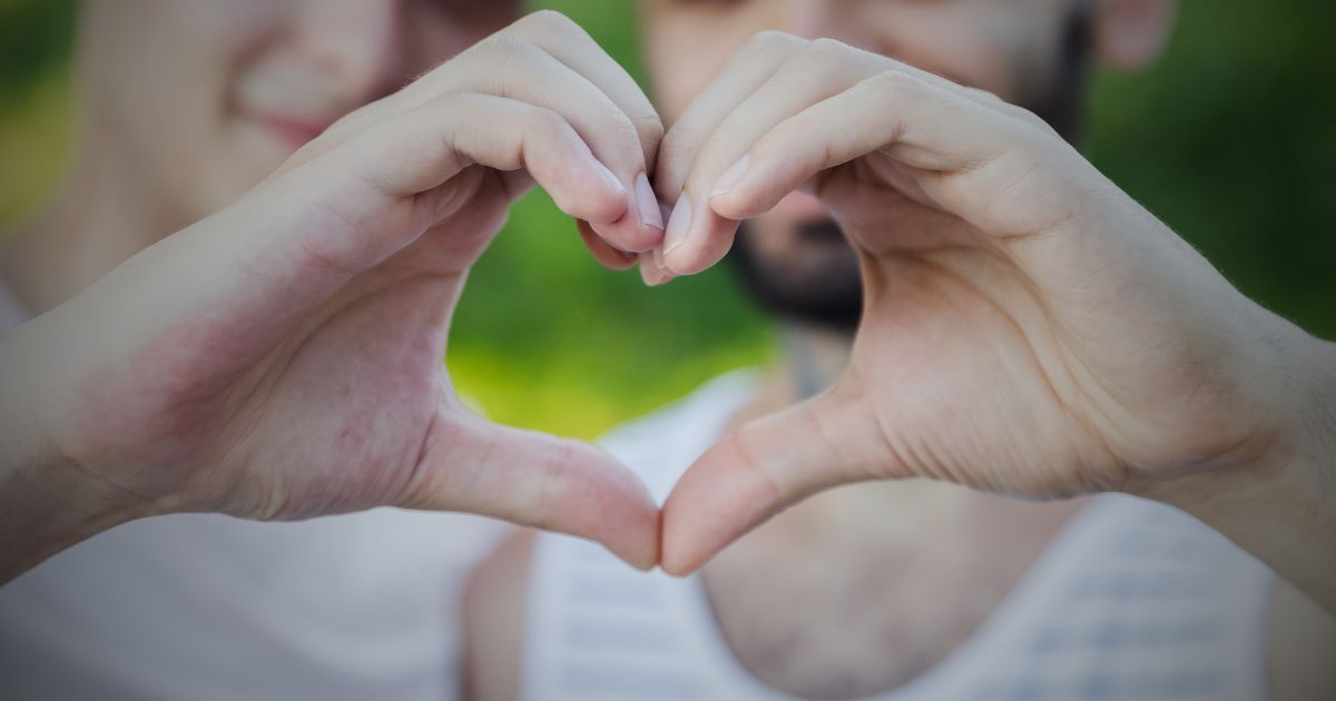 Dois homens formam coração com as mãos, homossexualidade. Foto D-Keine Dois homens formam coração com as mãos, homossexualidade. Foto D-Keine