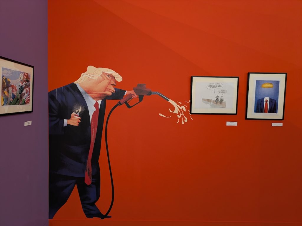 Reprodução do cartoon Trump contra transição verde, de André Carrilho, na exposição Cartoon Xira 2026