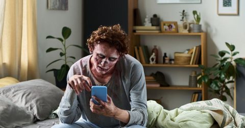 Zombie a usar smartphone. Foto Pressmaster