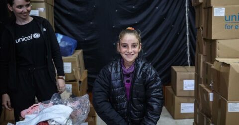 UNICEF lança apelo para proteger 540 mil crianças palestinianas do inverno © UNICEFEyad El Baba Uma menina em Gaza recebe um casaco quente antes da chegada do inverno em 2025